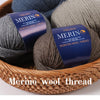 A bundle of YEDAN MERINO worsted wool thread yarn in gray and beige colors resting in a woven basket.