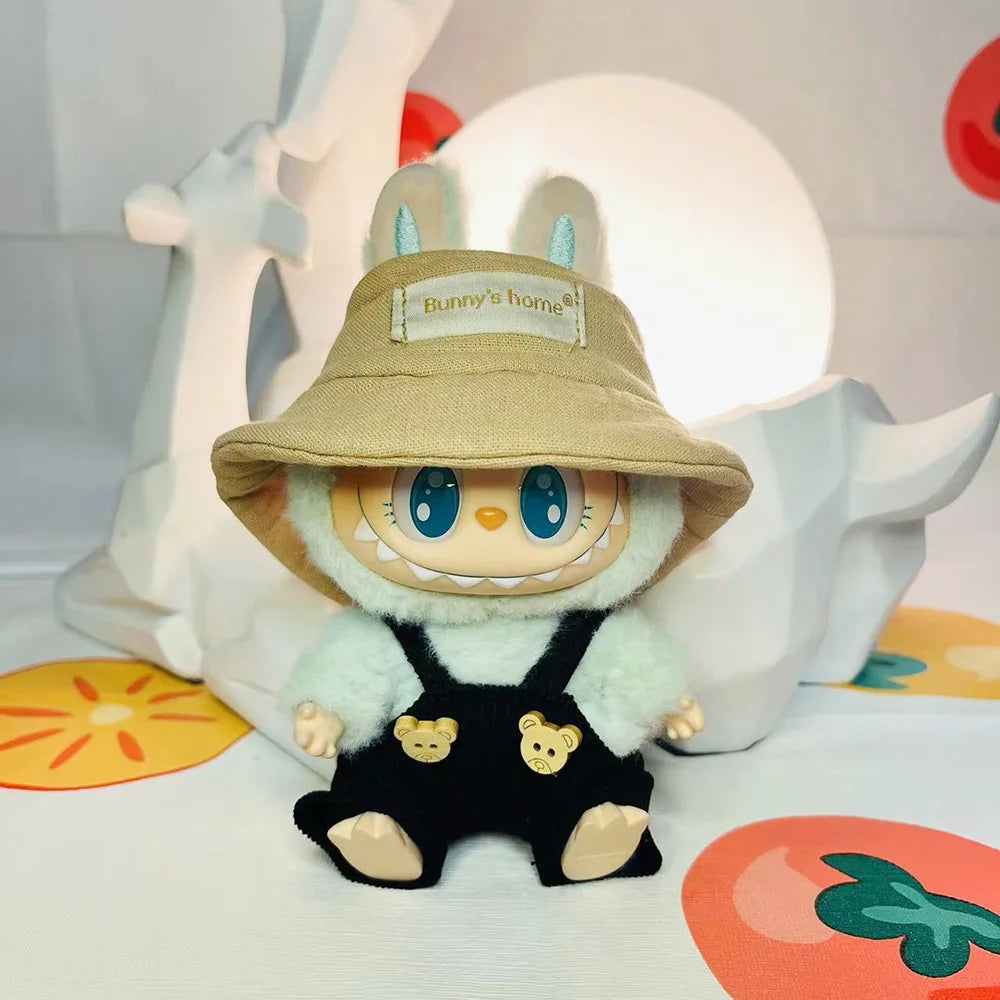 A Labubu doll wearing a beige hat and black bear hoodie with headphones, displayed against a white background.