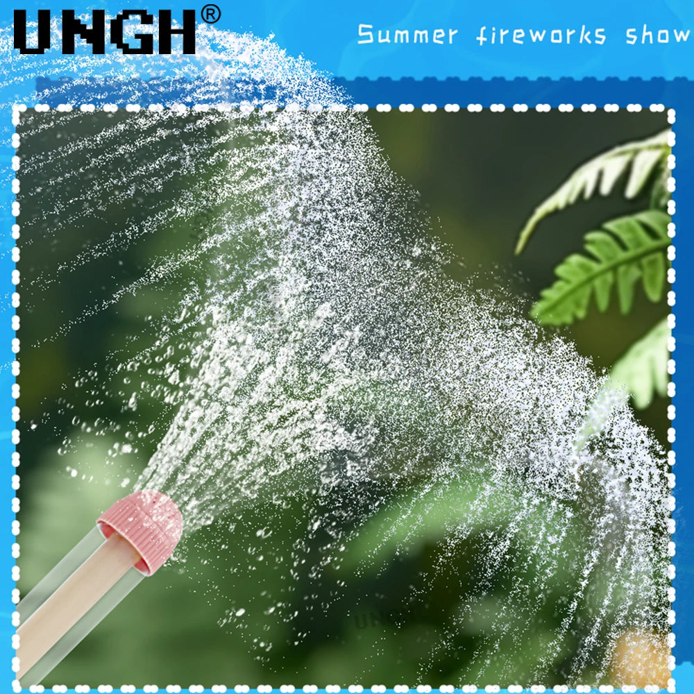 A pink pull-out water gun sprays a fine mist of water into the air against a blurred green background.
