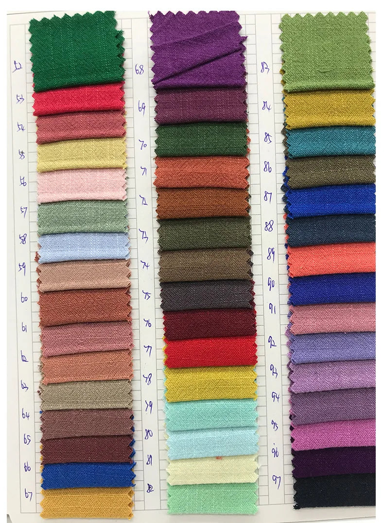 A collection of folded fabric napkins in various shades of green, pink, beige, and blue.
