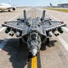 A detailed model kit of a J35 fighter jet built from gray building blocks on an airfield tarmac.