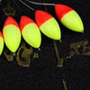 A row of bright red and yellow oval fishing floats with bobber beads are shown against a dark background with scale markings.
