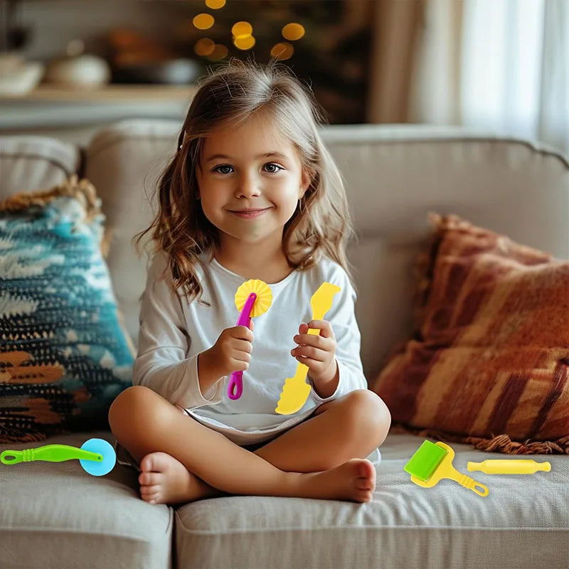 A young girl holds a set of yellow and green creative play dough tools on a sofa.