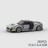 A gray classic rally car building block set with a black roof and yellow accents.