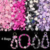 A variety of pink, purple, and iridescent acrylic beads and stringing materials for DIY jewelry making.