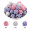A pile of colorful rhinestone resin bayberry beads in pink, purple, and white for jewelry making