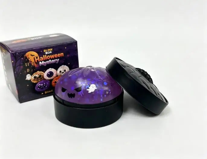 A black box of Halloween Mystery Blink Box and a black squishy stress relief toy with a purple glow.