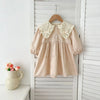 A light pink cotton party dress for girls featuring lace collar details, displayed on a wooden hanger against a white backgro