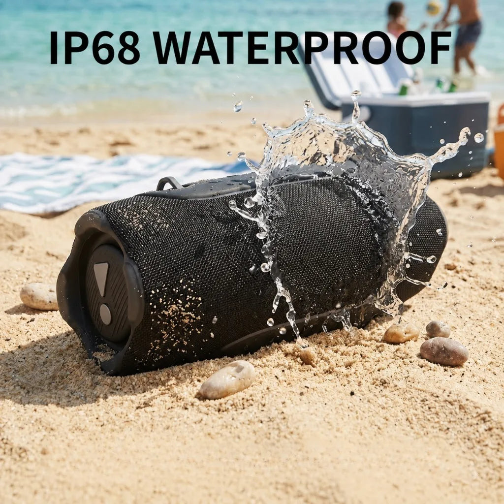 A black portable Bluetooth speaker is shown being splashed by water on a sandy beach.