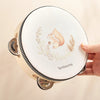 A wooden bear musical instrument set with a light cream-colored lid featuring a delicate illustration of a bear and foliage.