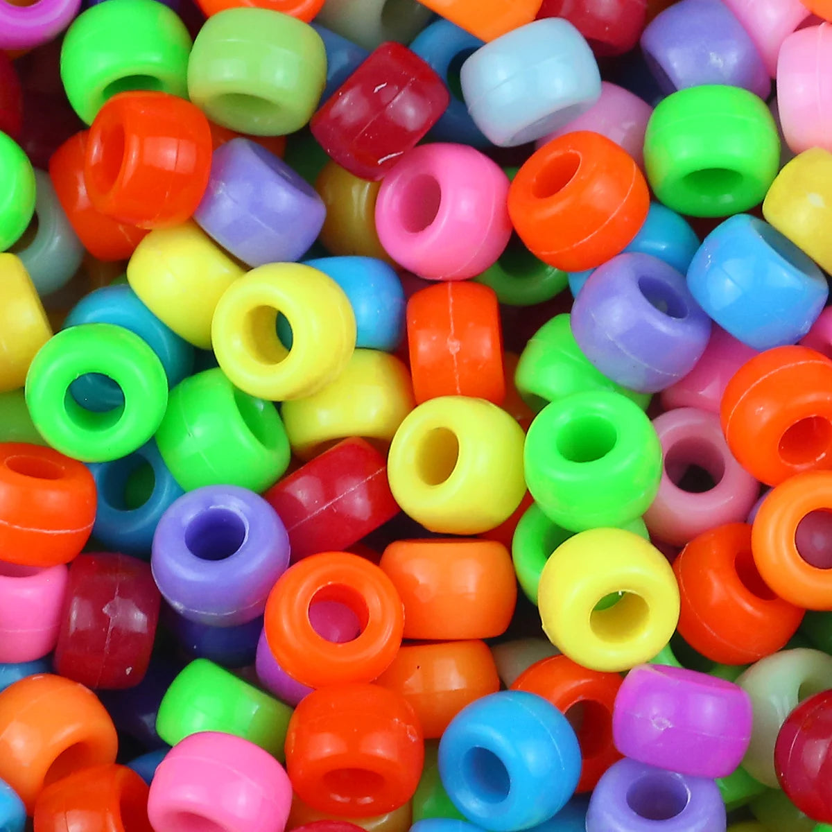 A close-up view of a pile of colorful pony beads in various shades of green, yellow, orange, pink, and blue.