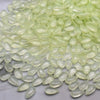 A pile of translucent pale green water drop Czech glass beads for jewelry making.