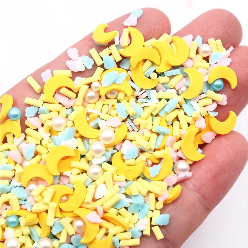 A hand holds a pile of yellow and pastel colored polymer clay slices for DIY crafts