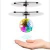 A hand is holding a floating, iridescent crystal ball above a drone for gesture control.