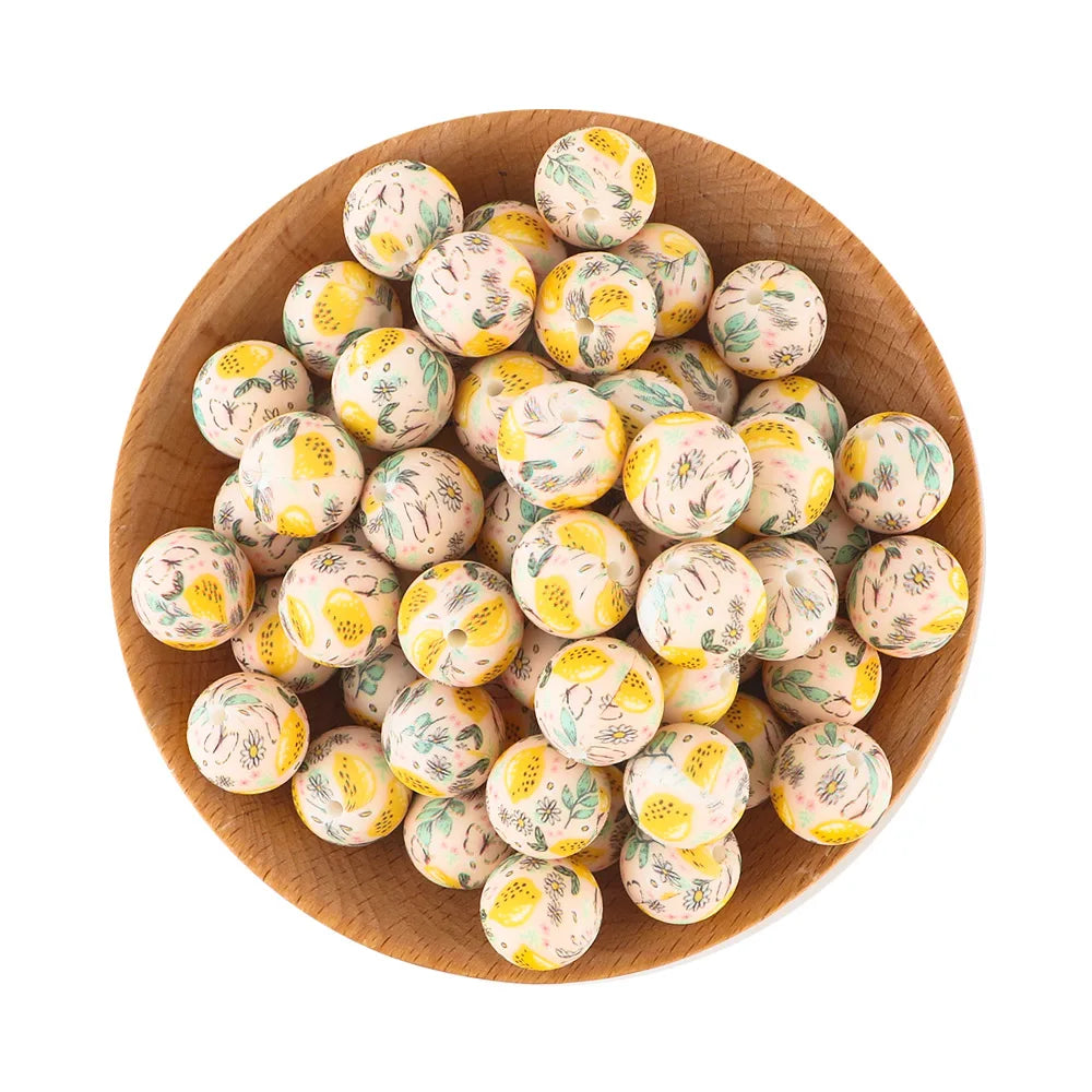 A wooden bowl filled with small, round, pale green and yellow silicone beads for jewelry making.