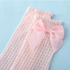 Pink baby girl lace knee socks with a pink bow displayed on a light blue background.