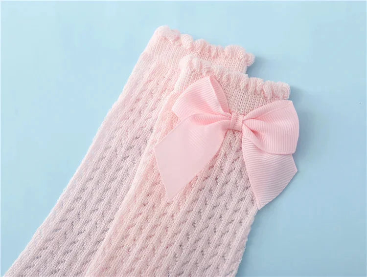 Pink baby girl lace knee socks with a pink bow displayed on a light blue background.
