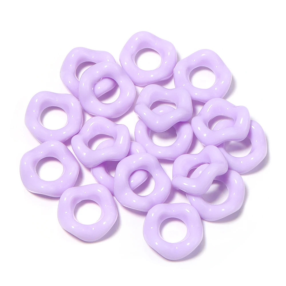 A pile of purple acrylic doughnut spacer beads for jewelry making