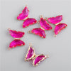 Gold-toned crystal butterfly charm beads in vibrant pink and magenta hues