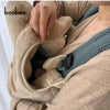 A person is holding a beige baby windproof cape blanket with a dinosaur design.