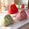 A collection of silicone molds shaped like roses and flowers for candle and soap making displayed on a marble surface.
