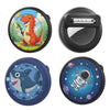 Four silicone airtag safety pin holders featuring a dinosaur, a silver box, a whale, and an astronaut in space.