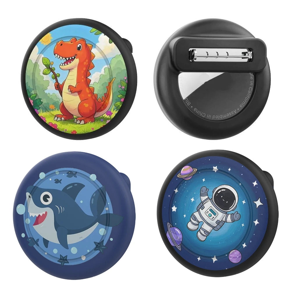 Four silicone airtag safety pin holders featuring a dinosaur, a silver box, a whale, and an astronaut in space.