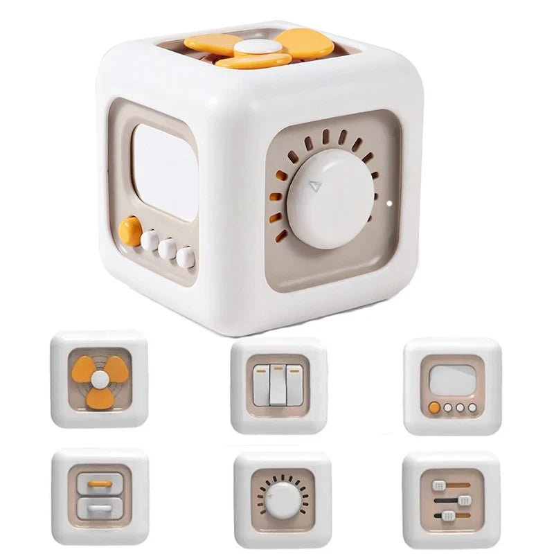 A white, cube-shaped toy with a round window and a dial, featuring various animal-themed buttons for cause and effect learnin