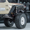 Close-up of a beige RC truck with heavy-duty oil shocks and large tires.