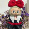 A handmade Halloween pumpkin costume set for a doll featuring a red bow and carved face.