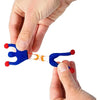 A hand is holding a blue sticky wall climber toy with orange connectors, demonstrating the product.