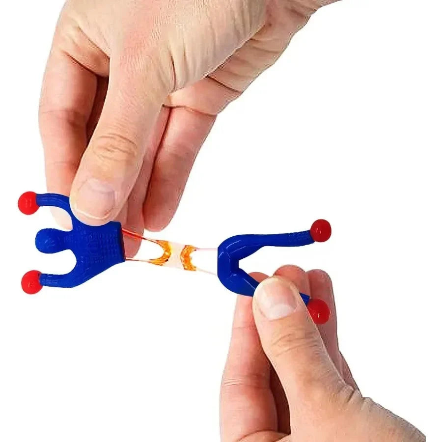 A hand is holding a blue sticky wall climber toy with orange connectors, demonstrating the product.