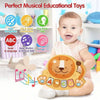 A baby is holding an orange lion-themed musical educational toy for sensory and motor skill development.