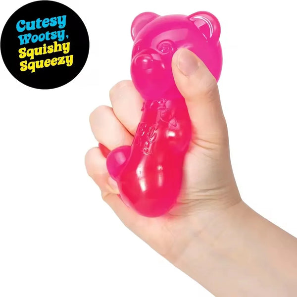 A hand is squeezing a bright pink squishy toy shaped like a bear for sensory relief.