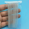 A hand holds a clear plastic package containing multiple transparent ring size adjusters.