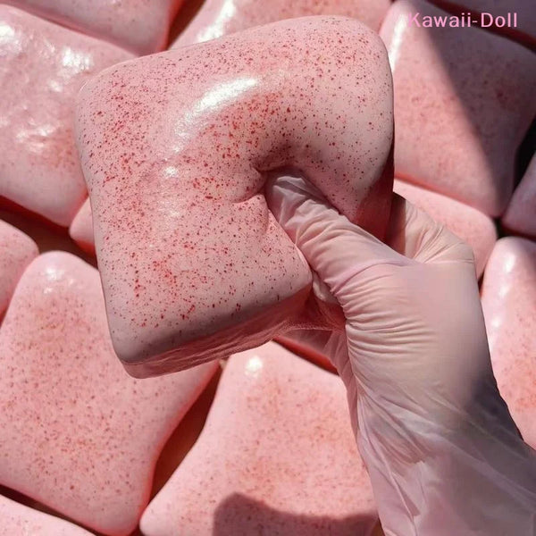 A hand in a white glove is squeezing a pink, speckled clay toy for sensory stress relief.