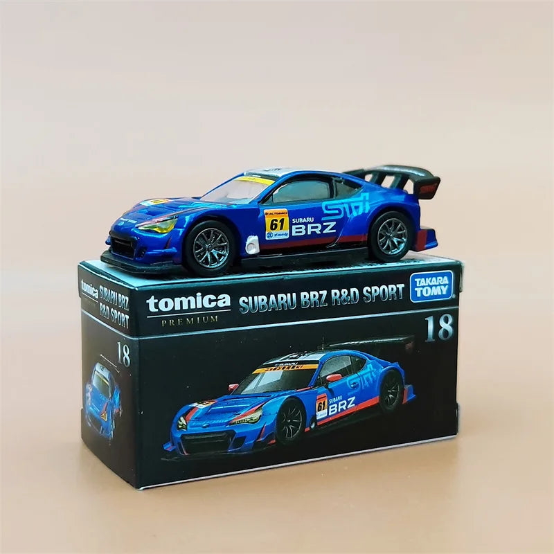 A blue and orange Tomica Subaru BRZ R&D Sport die-cast model car in its box.