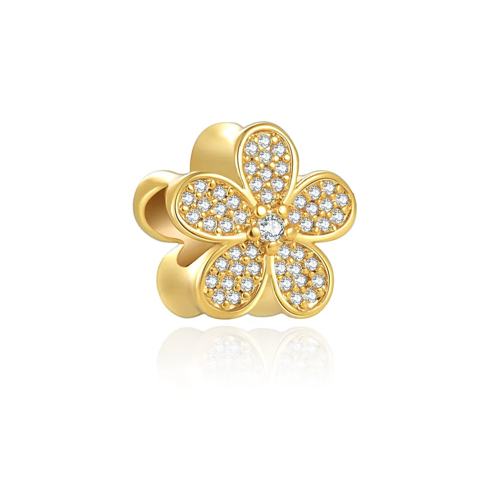 A gold-toned charm bracelet featuring pendants shaped like an elephant, key, butterfly, and heart.