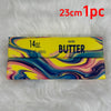 A rectangular bar of salted butter with colorful marbled patterns is displayed on a white fluffy surface.