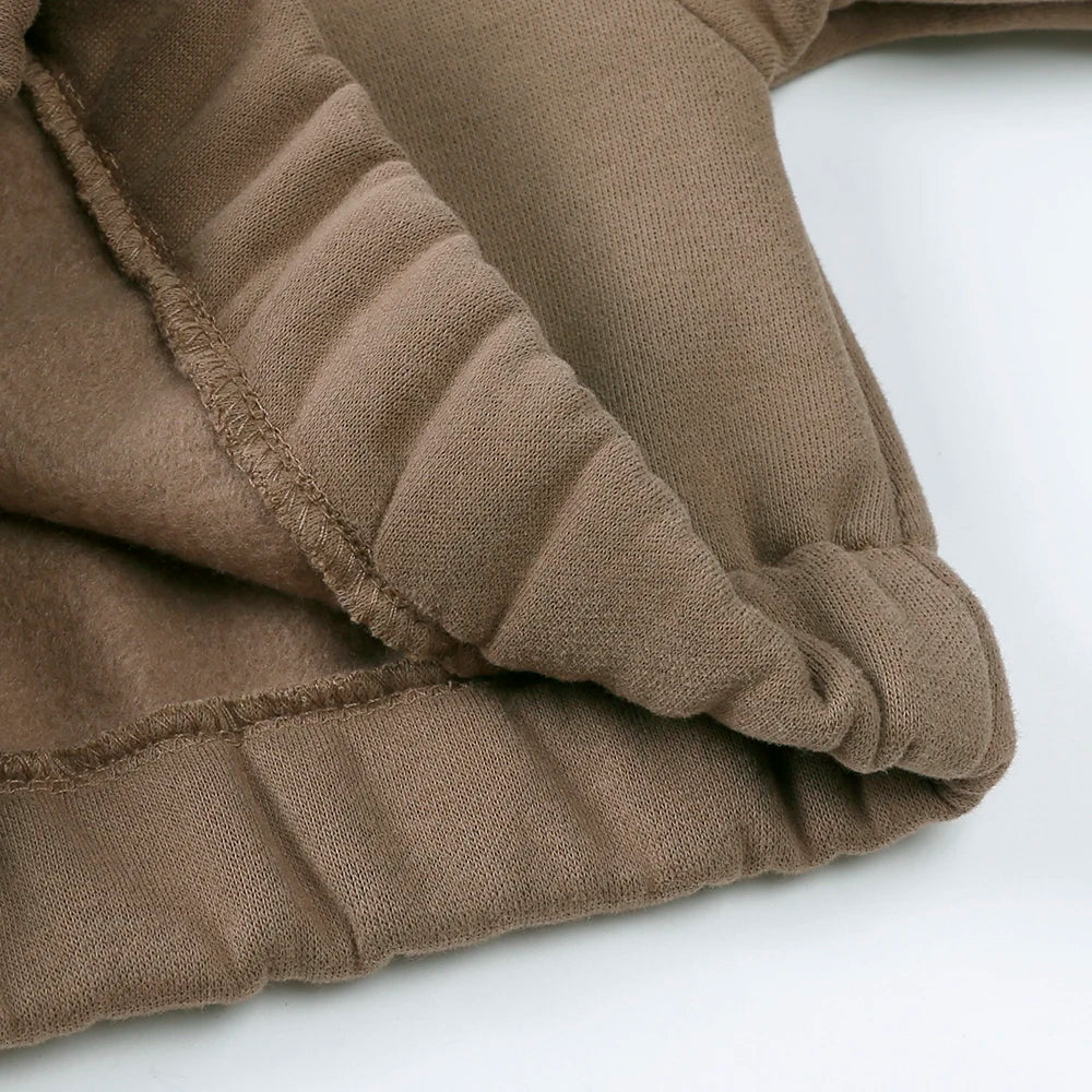 A close-up of a brown fleece hooded tracksuit set for children, showing the ribbed texture and fabric detail.