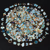A circular arrangement of assorted small metal pendants and charms in various colors including gold, silver, and blue.