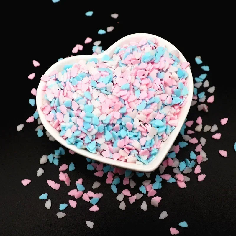 A heart-shaped dish filled with pink and blue polymer clay sprinkles for slime and craft decor