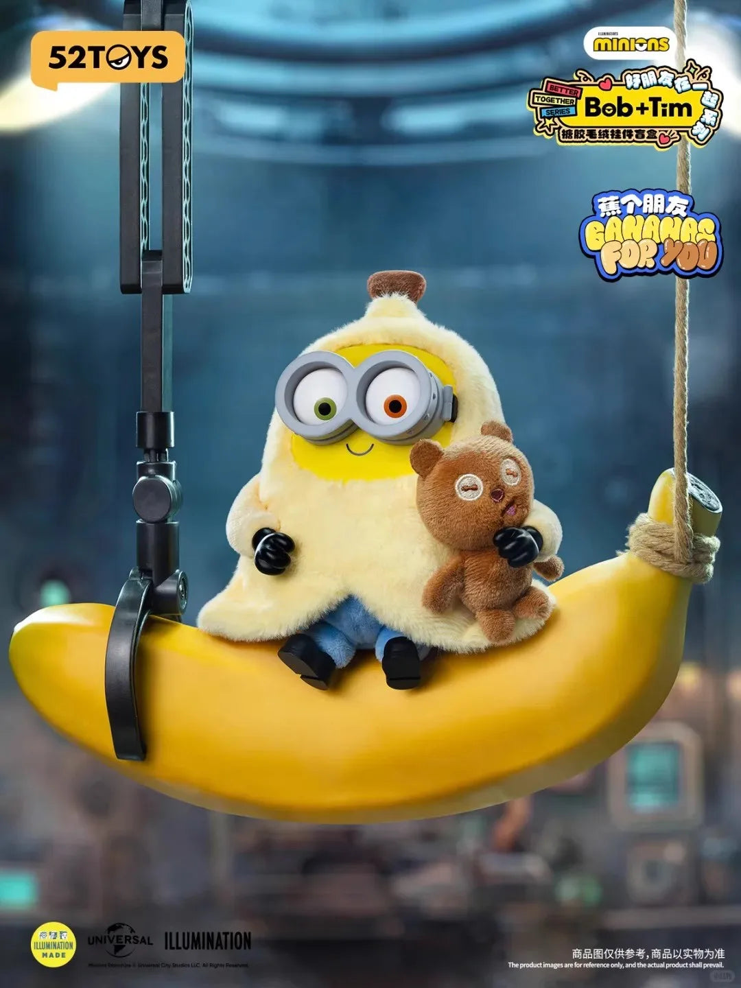 A yellow banana shaped toy featuring a plush character with large glasses and a small brown bear, suspended by a string.