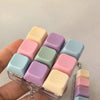 A hand holds a clear silicone pastel keyboard keychain fidget toy with various colored buttons.