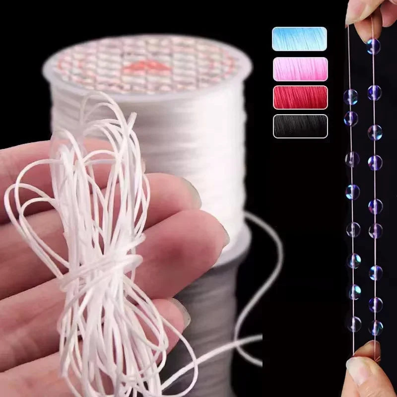 A hand holds a spool of white elastic beading cord with various colored strands and finished beaded necklaces.