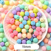 A close-up view of various pastel bear-shaped acrylic craft beads in shades of pink, yellow, green, and purple.