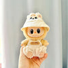 A cute Labubu doll wearing a beige hoodie and hat with headphones is held in a hand.