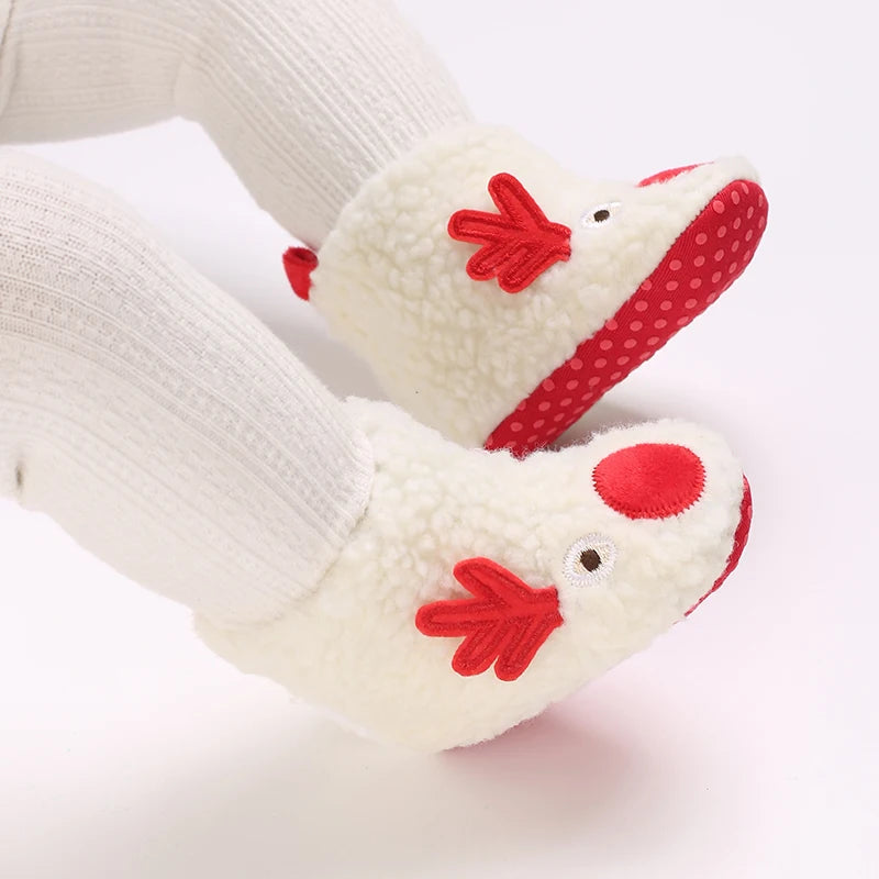A pair of white baby first walker shoes shaped like a reindeer with red accents.