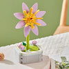A pink rose flower building block bouquet set with yellow stamens displayed on a white surface.