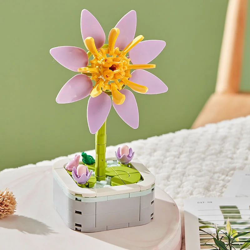 A pink rose flower building block bouquet set with yellow stamens displayed on a white surface.
